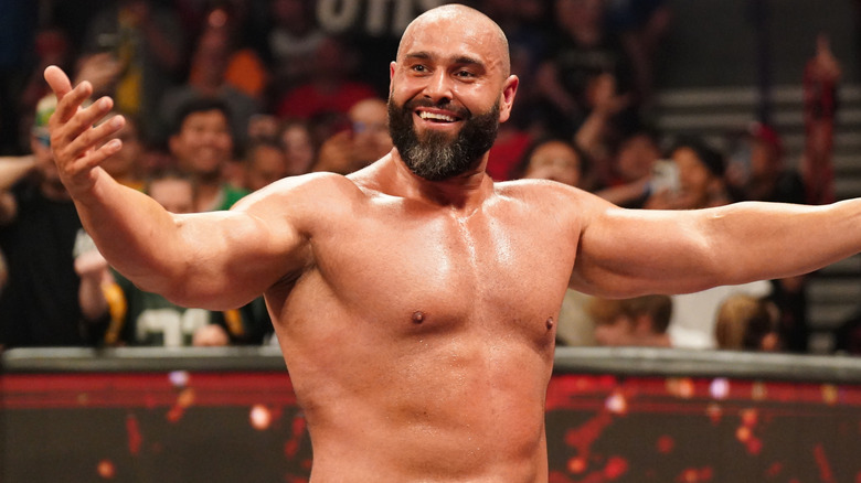 Rusev is stretching out his arms