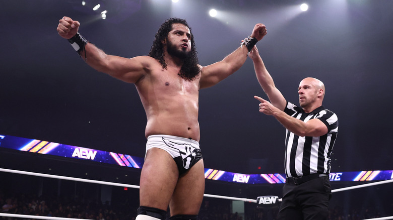 A referee holds up the arm of Rush as he stands over a fallen opponent after a victory on an episode of 