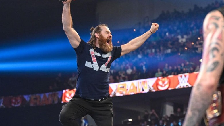 Sami Zayn stands in the turnbuckles