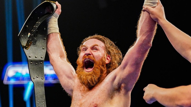 A referee holds up Sami Zayn's hand in victory after he defeated Solo Sikoa for the United States Championship on an episode of 