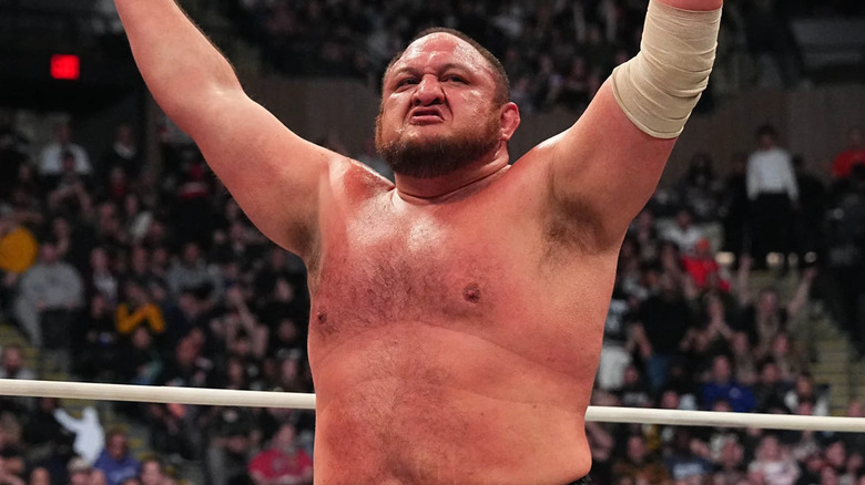 Samoa Joe raises his arms in the air