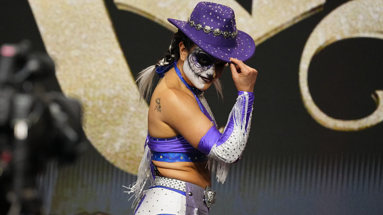 Thunder Rosa poses in a purple cowboy hat on the stage before heading down to the ring for a match on an episode of AEW programming.