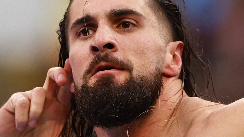 Seth Rollins holds his ear up to the crowd