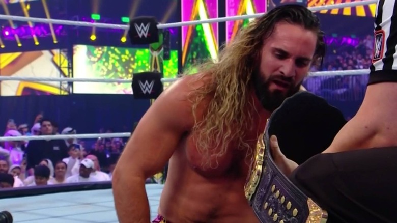 Seth Rollins looking at the title