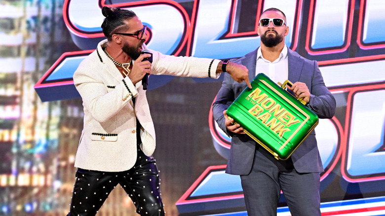 Seth Rollins with Bron Breakker holding the Money In The Bank briefcase