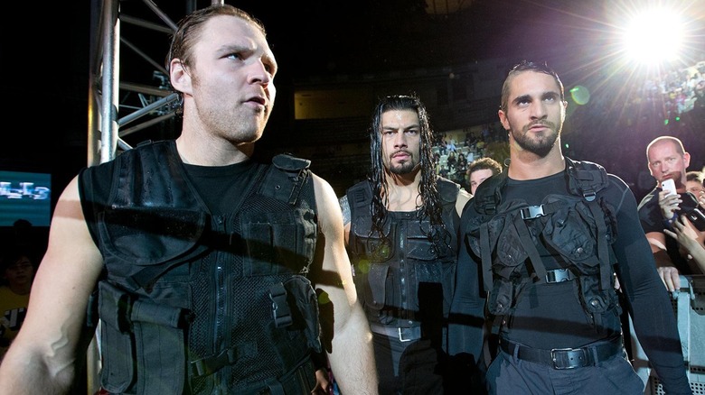 Dean Ambrose, Roman Reigns, and Seth Rollins walk through crowd