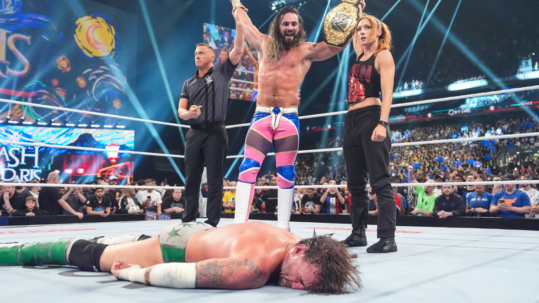 WWE World Heavyweight Champion Seth Rollins stands over CM Punk and beside Becky Lynch at WWE Clash in Paris