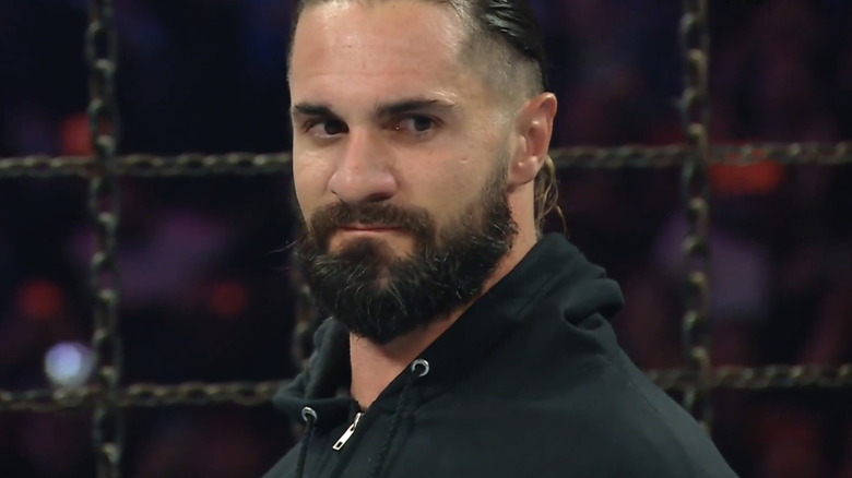 Donned in a black hoodie, Seth Rollins looks on.