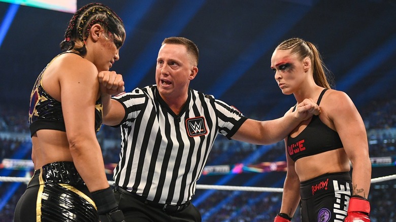 Shayna Baszler and Ronda Rousey facing off in a WWE ring with a referee present