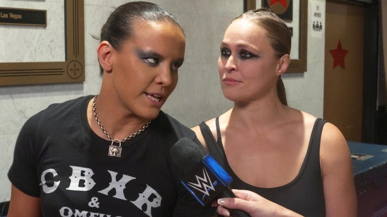 Shayna Baszler speaking as Rousey looks at her