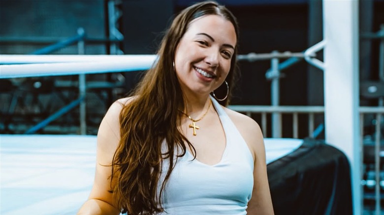 Sherilyn Guerrero posing in front of a ring while visiting Reality of Wrestling.