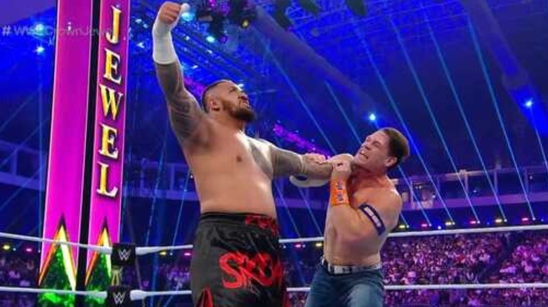 Solo Sikoa holding up John Cena 