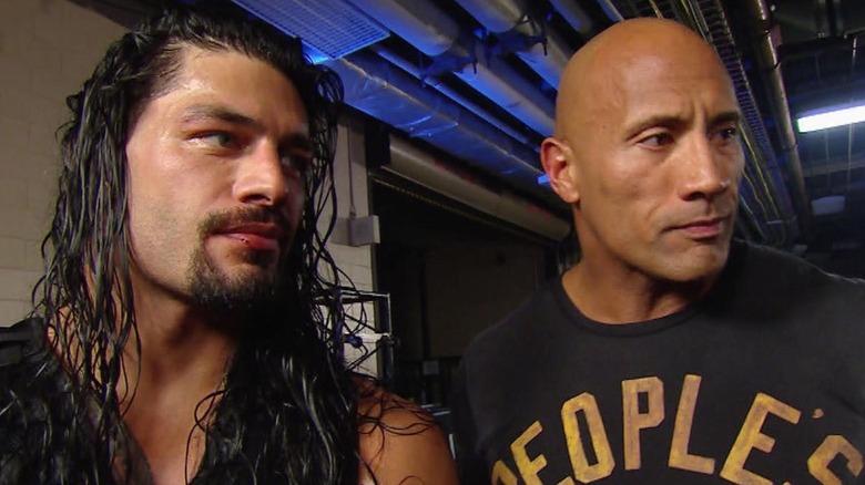 Roman Reigns standing next to Dwayne The Rock Johnson