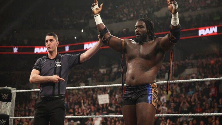 A referee holds up the hand of Oba Femi following a victory on 
