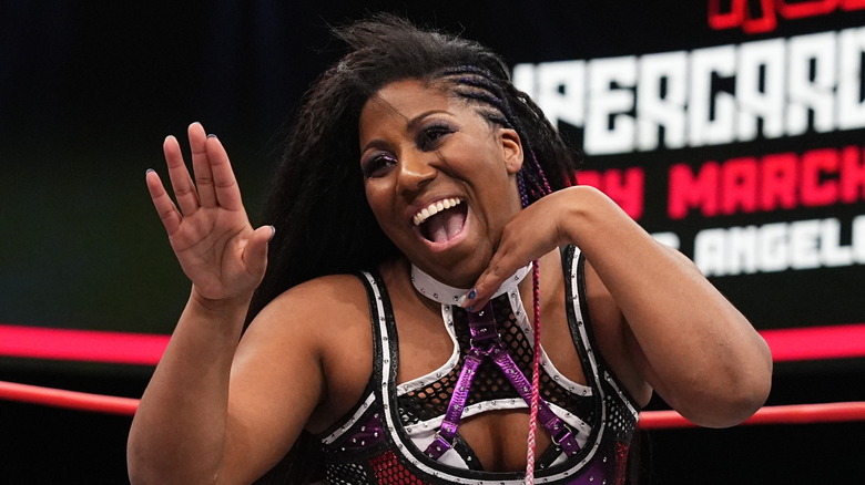 Athena smiling and raising her hand at opponent