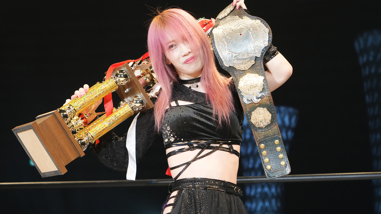 Saki Kashima holding a trophy and the High Speed Championship while smiling