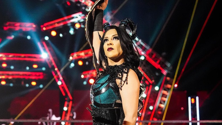 Stephanie Vaquer holds up the Women's World Championship in the middle of the ring before a match.