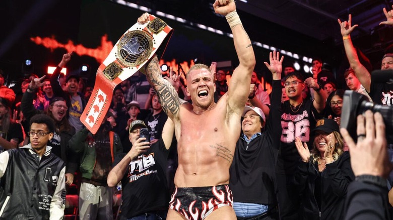 Myles Borne holds up the North American Championship while celebrating with the crowd in the WWE Performance Center after defeating Ethan Page on 
