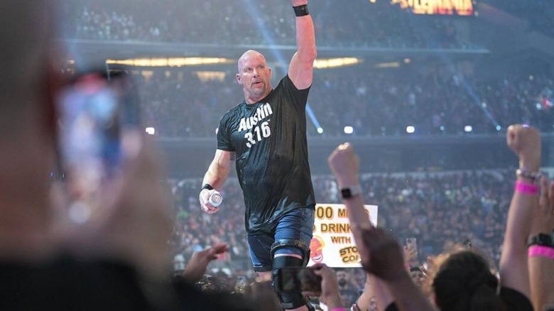 "Stone Cold" Steve Austin heads up the ramp, doused in beer and carrying another can, following his match at WrestleMania 38.