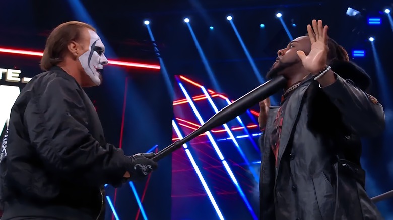 Sting holds a bat underneath Swerve Strickland's chin