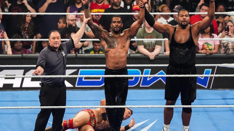A referee holds up the arm of Montez Ford and Angelo Dawkins raises his other hand after a win on 