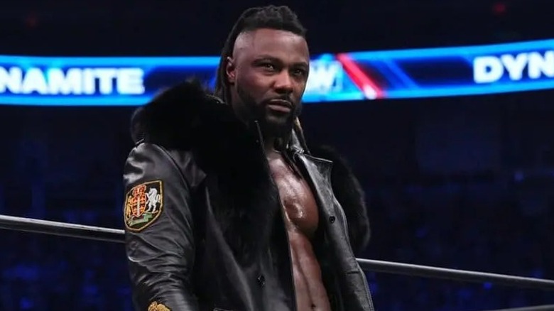 On the apron of the ring, Swerve Strickland looks on before heading inside the ring for his scheduled match