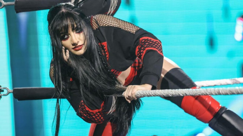 Tatum Paxley looks to the crowd while getting into the ring through the ropes on an episode of 