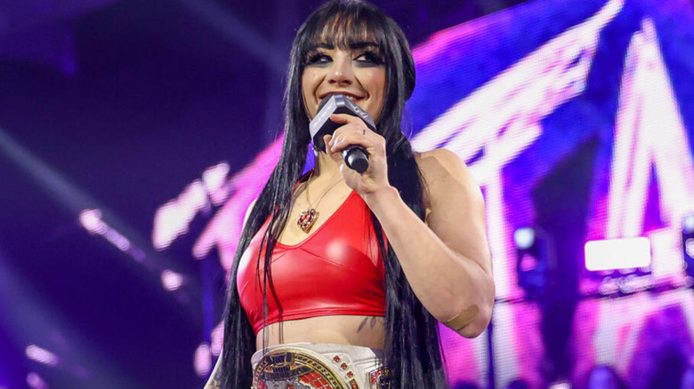 Tatum Paxley holding a microphone and smiling