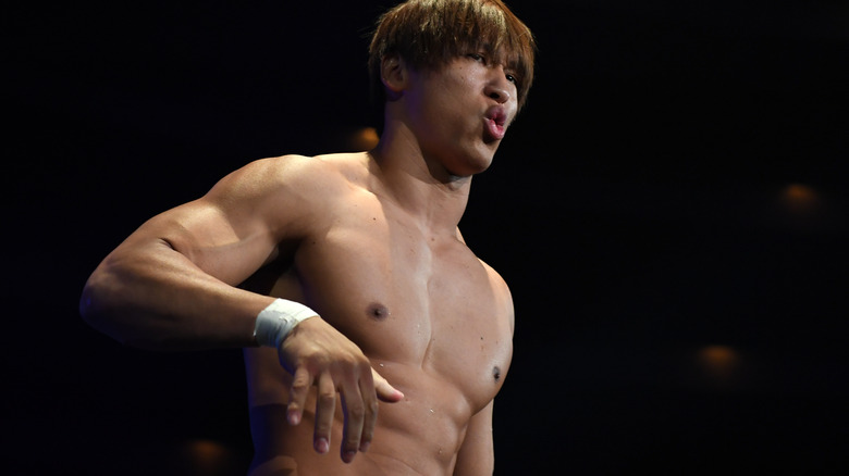 Kota Ibushi puckering his lips with his right hand up