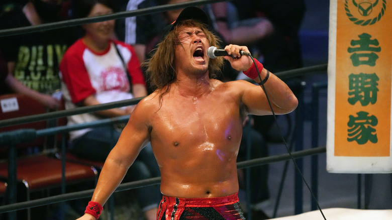 Tetsuya Naito holding a microphone