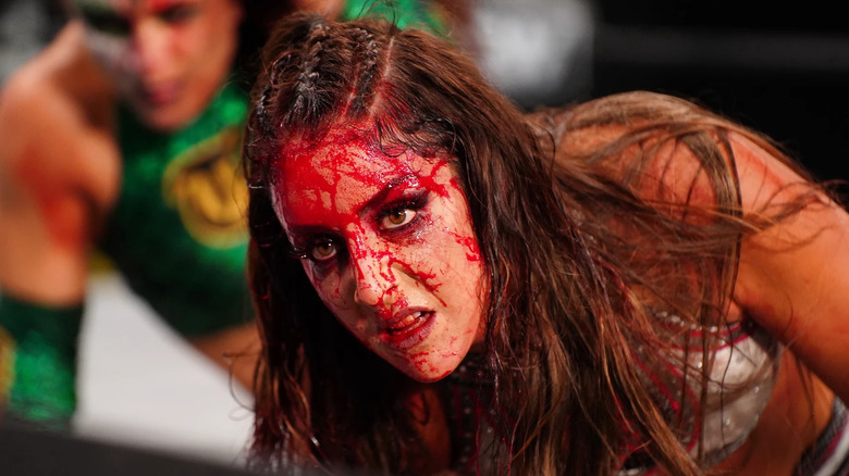 A bloody Britt Baker, with Thunder Rosa looming behind her