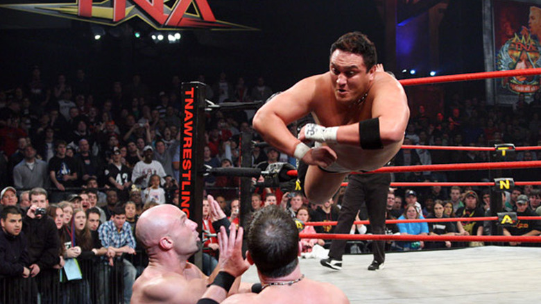 Joe dives out of the ring onto Daniels & Styles