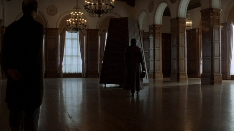 Hugh Jackman stands in front of a big box in The Prestige