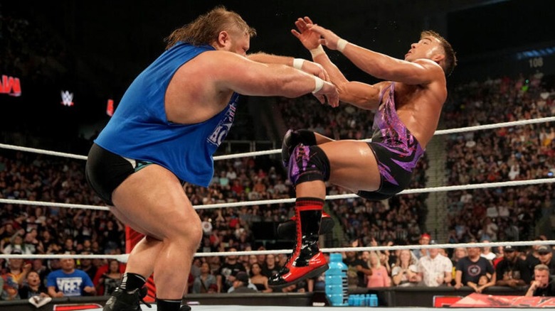 Otis pushes Chad Gable in the middle of the ring.