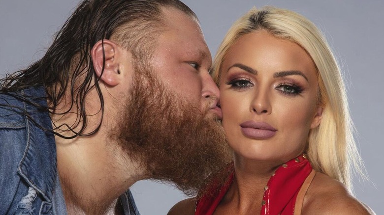 WWE star Otis plants a kiss on the cheek of Mandy Rose during a backstage photoshoot for WWE.com.