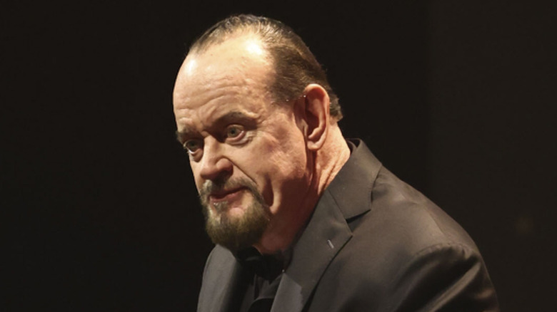 Undertaker poses in WWE ring with fist raised in the air