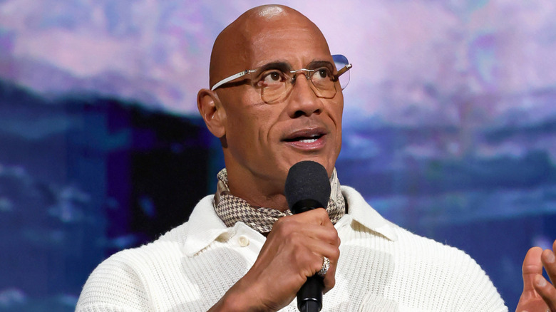 The Rock holding a microphone