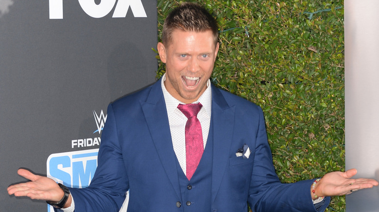 The Miz wearing a blue suit and posing at a promo event
