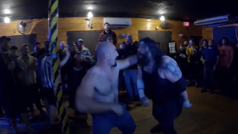 Cass and Slade fighting amongst the people