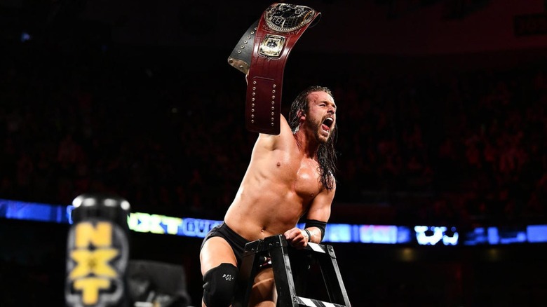 Adam Cole holds up championship