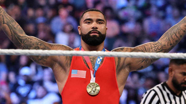 Gable Steveson poses in the ring wearing his Olympic gold medal before a match on WWE programming.
