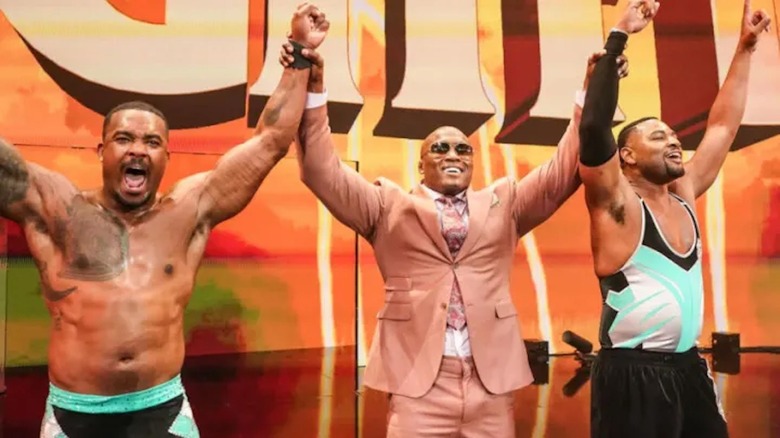 Bobby Lashley and The Street Profits celebrate.