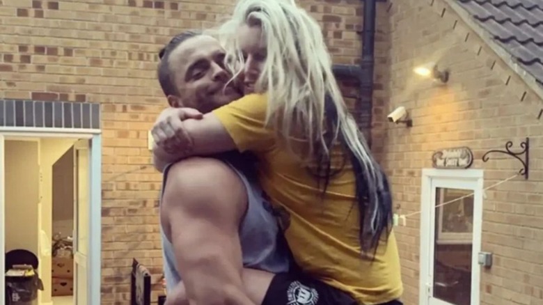 Juice Robinson holds up his wife, Toni Storm, and the pair smile for the camera in a photo posted to her Instagram account.