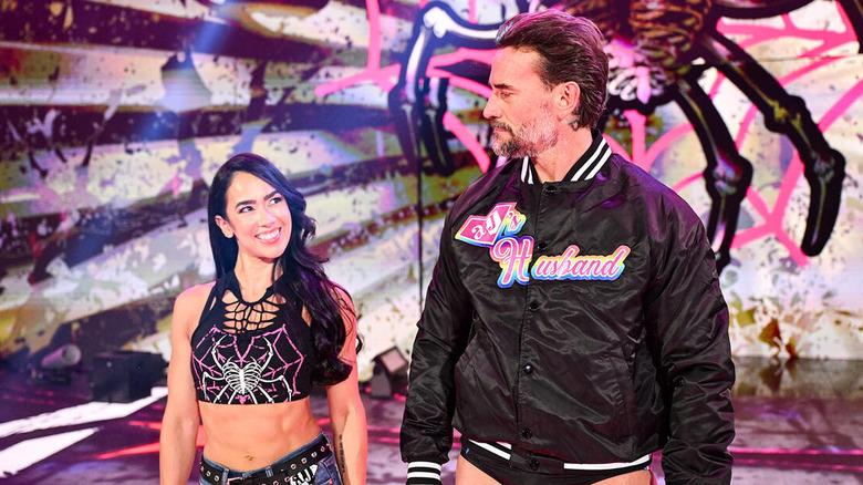 CM Punk looks to his wife, AJ Lee, on the stage during their entrance at Wrestlepalooza.