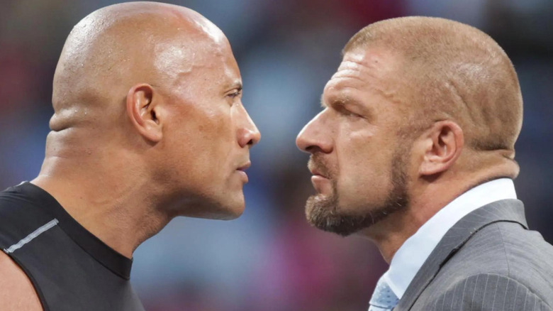 The Rock and Triple H staring at each other
