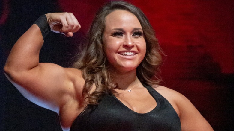 Jordynne Grace flexes while wearing the Knockouts Championship around her waist before a match.