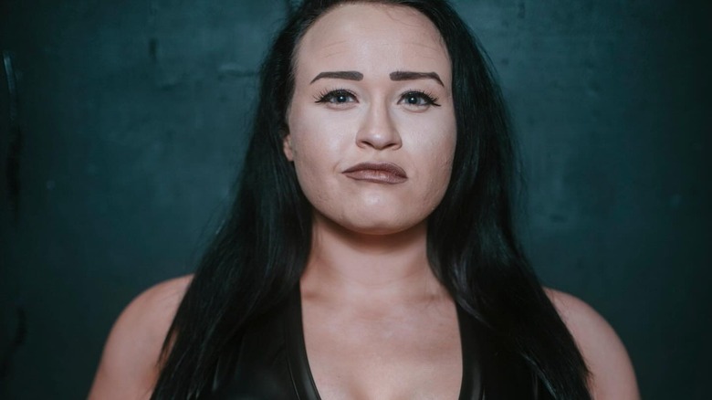 Jordynne Grace poses and smirks to the camera, while wearing the Progress World Women's Championship, in a photo posted to the promotion's website.