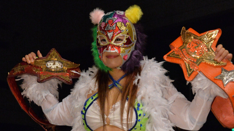 Io Shirai heads down to the Stardom ring wearing a mask and all of her championship belts before a match.