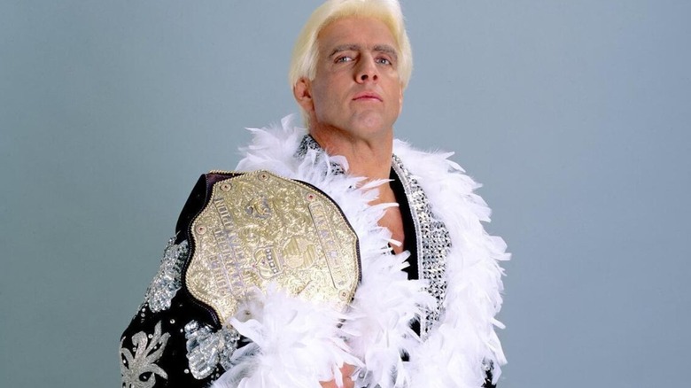Ric Flair poses backstage with a world championship.