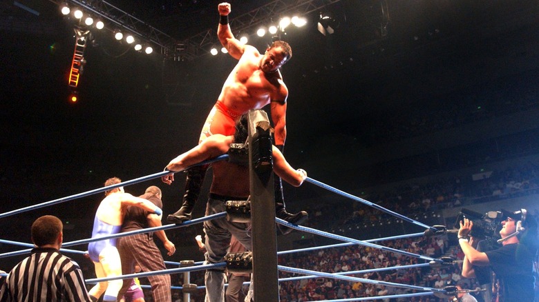 Buff Bagwell punches a guy in the corner while standing on the second rope